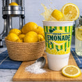 Gold Medal Fresh Lemonade cup with fresh lemons and juicer, illustrating ingredients used to make lemon shake-ups.