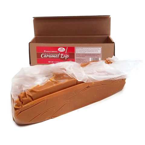 Long rectangle brown box, lid open with a red label saying Old Fashioned Caramel Dip in red, white and brown. Block a caramel in a clear bag sitting in front of box.