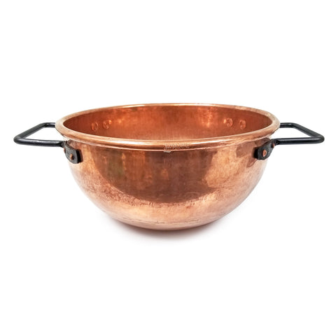 Copper kettle with two black handles, side view.